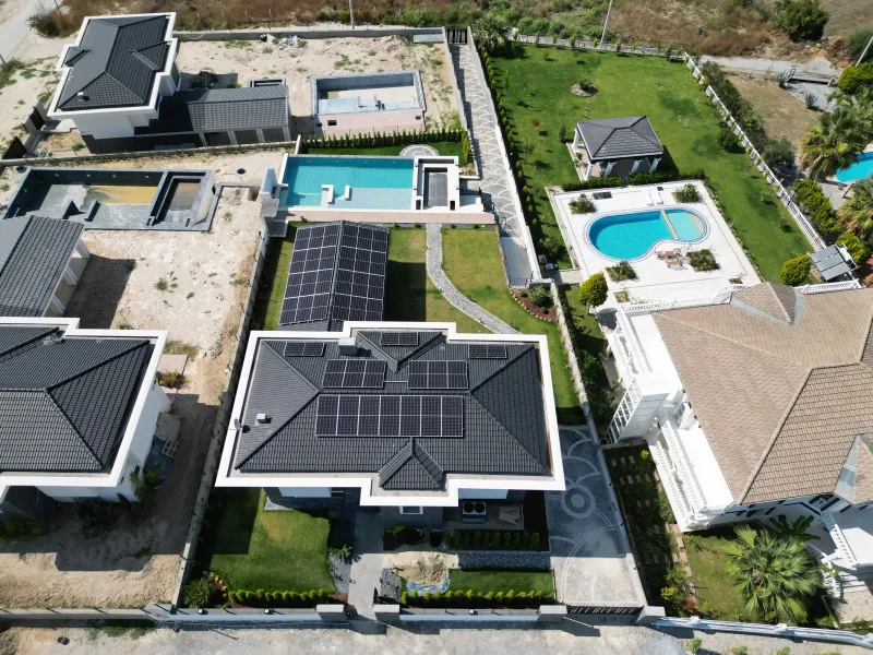 Aton Enerji referans projesi (Kuşadası hibrit GES) — villa çatı üstü panel dizisi